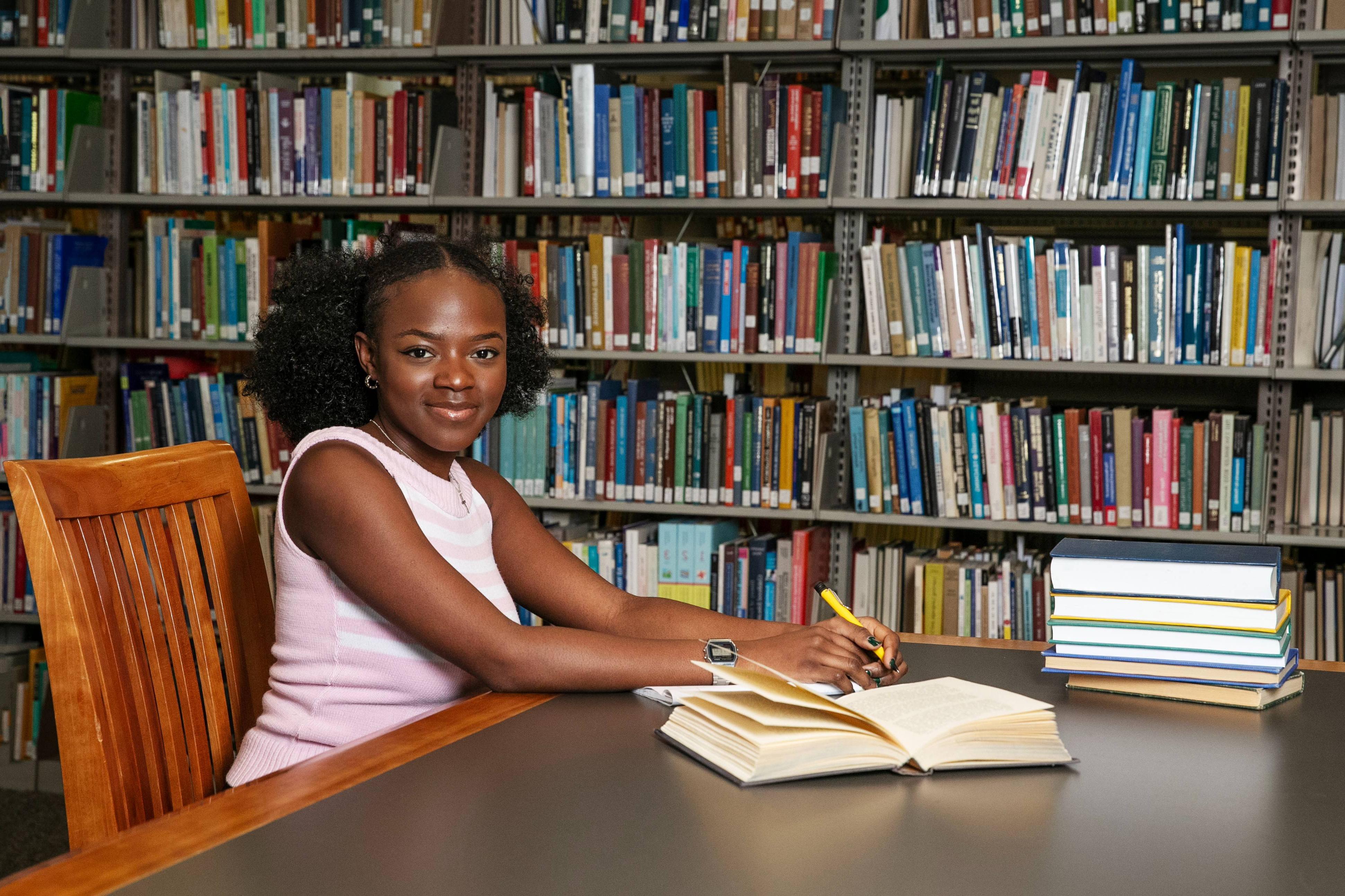 A photo of me, Anesu Mukombiwa ' 24, in Skidmore’s Scribner Library, doing what I love: 写作. 